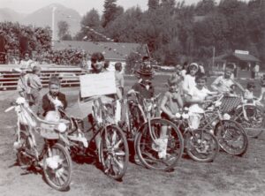 Kids on decorated bikes in a black and white photo from the 1970s of a spring fair