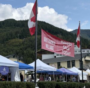 A series of tents in a parking lot against the backdrop of a mountain 