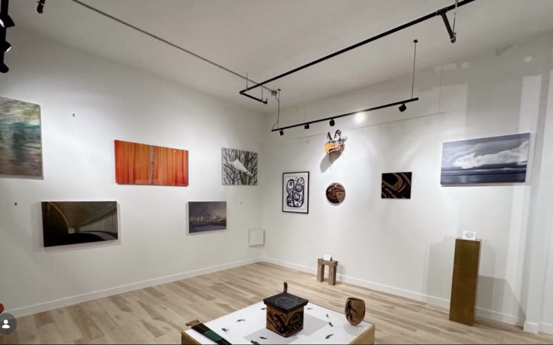 Art gallery with painting and photos hung on a white wall